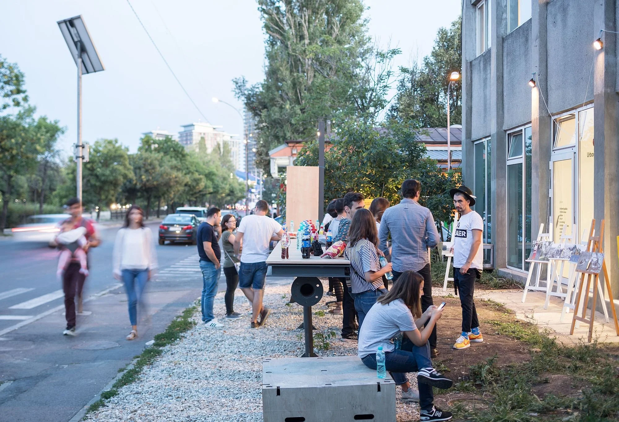 În poză vedem mai mulți oameni care stau în grădina La Firul Ierbii