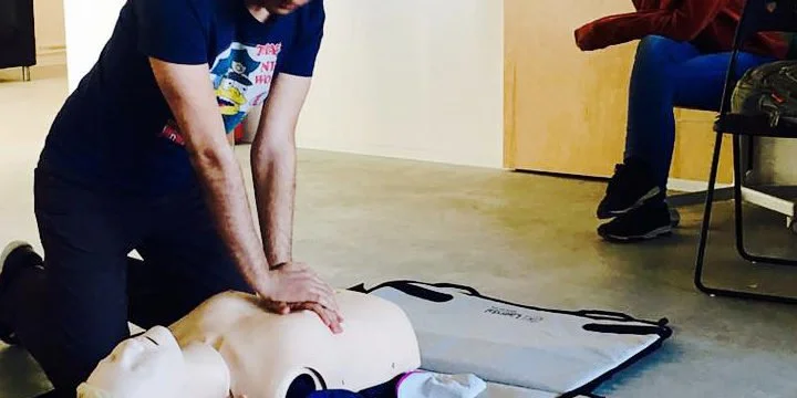 O persoană exemplifică lecțiile de prim ajuto pe un manechin din silicon